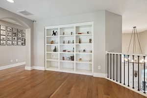 Upstairs loft space w/ hardwood flooring & built-in shelling nook.