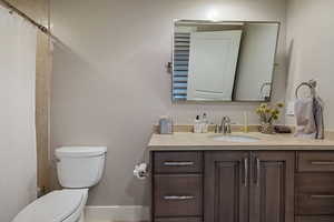 Basement full bathroom w/ granite counter, custom pivoting metal framed mirror & tile flooring.