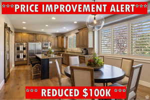 Kitchen with sink, dark wood-type flooring, built in appliances, decorative backsplash, and a kitchen island