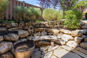 Private & secluded natural stone patio w/ bench & mature landscaping.