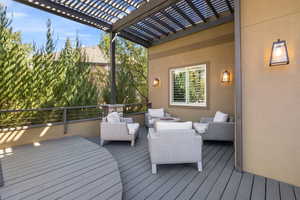 Rear back deck w/ secluded outdoor lounging nook & wooden trellis above.