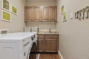 Laundry room w/ s.s. sink, granite counters, hardwood flooring & plenty of cabinet storage.