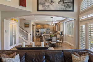 Open Family Rm. w/ hardwood flooring, recessed lighting, plantation shutters & large archway view into Kitchen area.