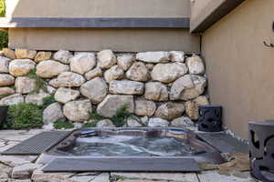 Secluded exterior natural stone nook featuring a sunken hot tub.