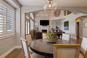 Semi Formal open spaced dining area off of kitchen w/ large archway opening into family room featuring hardwood flooring throughout.