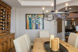 Dining space featuring an inviting chandelier and dark hardwood / wood-style flooring