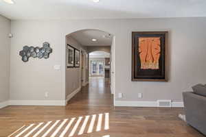 Hall featuring a textured ceiling and hardwood / wood-style floors