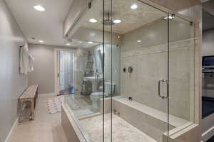 Basement bathroom w/ glass enclosedwalk-in steam shower, tile flooring & recessed lighting.