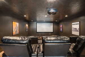 View of home theater room w/ powered reclining leather chairs.