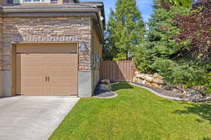 View of 3rd car garage & manicured sideyard w/ matured landscaping.