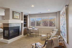 Primary Bedroom sitting/lounge nook separated by a multi-sided gas fireplace & large windows w/ plantation shutters.