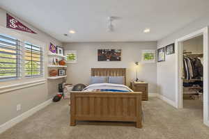 Guest Bedroom #2 w/ light carpet flooring, ceiling fan, recessed lighting & walk-in closet.