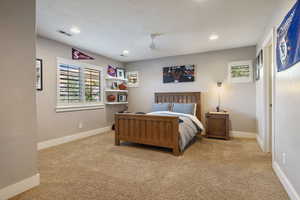 Guest Bedroom #2 w/ light carpet flooring, celing fan, recessed lighting & plantaion shutters.