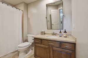 Full Bathroom w/ granite countertop vanity, custom pivoting metal framed mirror & tile flooring off of Guest Bedroom #4.