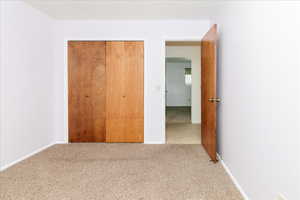 Unfurnished bedroom featuring carpet floors and a closet