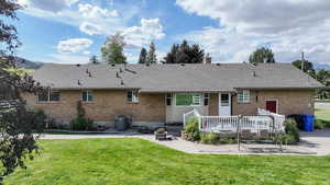 View of front of home with a front yard, a patio area, and central AC unit