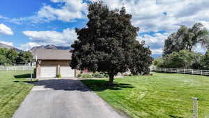 View of front facade with a mountain view, a front yard, and a garage