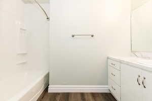 Bathroom featuring shower / tub combination, hardwood / wood-style flooring, and vanity