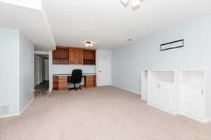 Family room with built in desk and light colored carpet