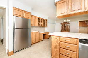 Kitchen with stainless steel refrigerator, built in desk, a chandelier, and kitchen peninsula