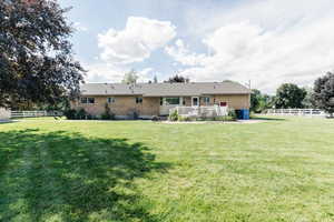 Rear view of house with a yard