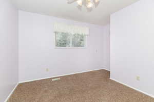 Carpeted spare room with ceiling fan