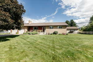 Ranch-style home featuring a front lawn