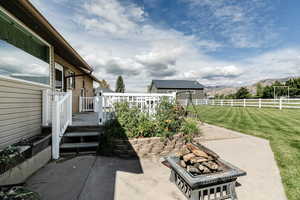 View of patio featuring a deck with mountain view and an outdoor fire pit