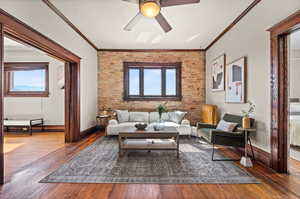 Living room with ceiling fan, ornamental molding, and hardwood / wood-style floors