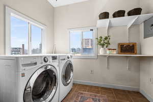 Laundry room with separate washer and dryer and dark tile patterned floors