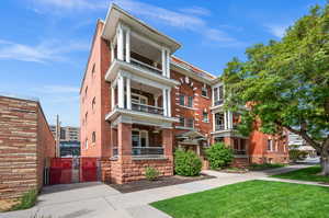 View of front of property featuring a balcony and a front lawn