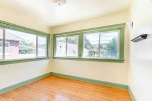 Unfurnished room with a healthy amount of sunlight and wood-type flooring