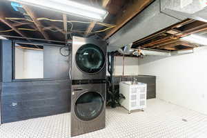 Laundry area with stacked washing maching and dryer