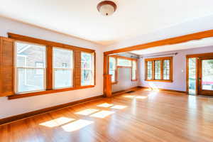 Spare room featuring light wood-type flooring and plenty of natural light