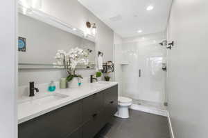 Bathroom with tile patterned flooring, vanity, toilet, and an enclosed shower