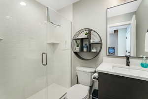 Bathroom with walk in shower, vanity, and toilet