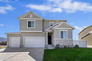 View of front of home with a garage and a front lawn