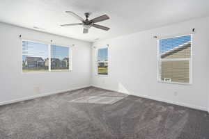 Spare room with carpet floors, a healthy amount of sunlight, and ceiling fan