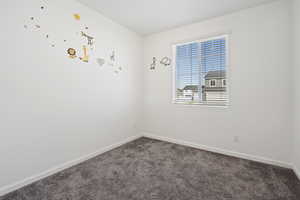 Empty room featuring dark carpet