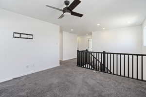 Carpeted spare room with ceiling fan