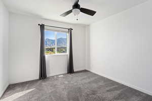 Carpeted spare room featuring ceiling fan and a mountain view