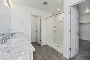 Bathroom featuring a shower, vanity, and hardwood / wood-style floors