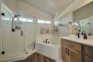 Primary suite bathroom featuring plus walk in shower,  vaulted ceiling, and vanity