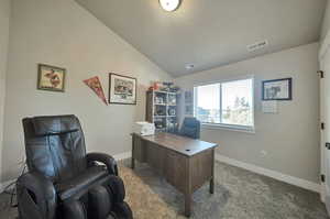 Office space with carpet flooring and vaulted ceiling