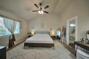 Primary suite bedroom with large window, ceiling fan and vaulted ceiling