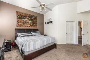 Bedroom with lofted ceiling, light carpet, and ceiling fan