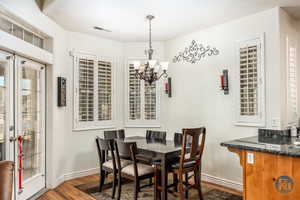 Dining space with a chandelier and dark hardwood / wood-style flooring