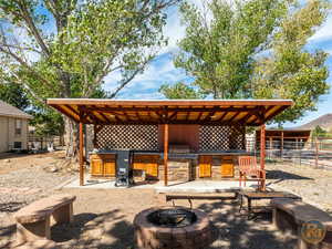 View of patio with grilling area and an outdoor fire pit