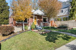 Obstructed view of property featuring covered porch and a front lawn