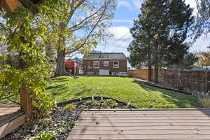 View of yard featuring a deck and a storage shed